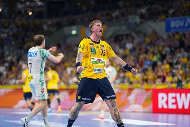 Edwin Aspenbäck 78 Rhein Neckar Löwen raises his fists and cheers loudly in his yellow jersey in the SAP Arena In the background is Felix Claar 7 SC Magdeburg in his white jersey Edwin Aspenbäck 78 Rhein Neckar Löwen cheers in the SAP Arena Copyright: xspeedshotx