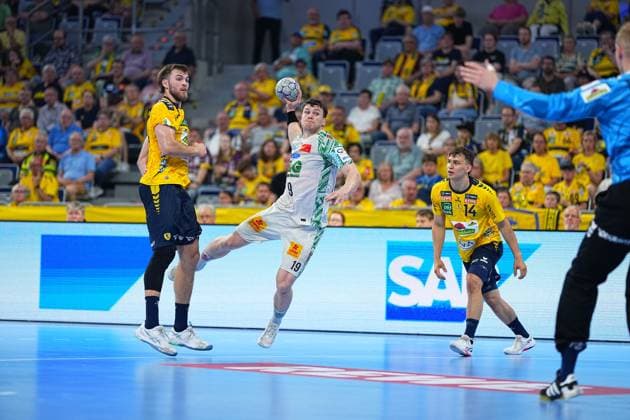 Elvar Örn Jonsson 19 SC Magdeburg in white jersey jumps for the shot in the SAP Arena, while Steven Plucnar Jacobsen 9 Rhein Neckar Löwen tries to block the shot Gino Steenaerts 14 Rhein Neckar Löwen observes the scene from the background, the Löwen goalkeeper in blue jersey can be seen on the right Elvar Örn Jonsson 19 SC Magdeburg pulls away against Rhein Neckar Löwen Copyright: xspeedshotx