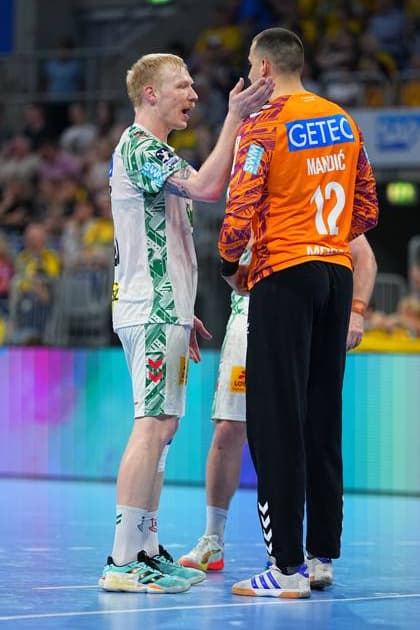 Magnus Saugstrup in the white SC Magdeburg jersey talks to goalkeeper Matej Mandi 12 in the orange goalkeeper jersey on the pitch of the SAP Arena Saugstrup puts a hand on Mandi s neck while both communicate with each other Magnus Saugstrup 23 SC Magdeburg in conversation with Matej Mandi 12 SC Magdeburg Copyright: xspeedshotx
