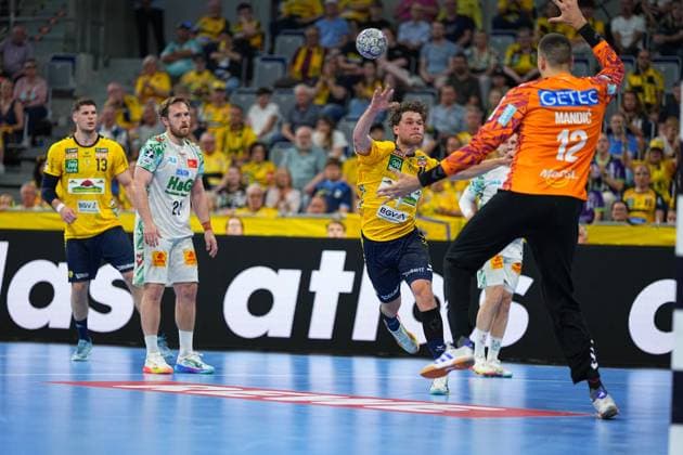 David Möré 15 Rhein Neckar Löwen jumps off in the SAP Arena and throws the ball towards SC Magdeburg goalkeeper Matej Mandi 12 In the background Sebastian Heymann 13 Rhein Neckar Löwen and Albin Lagergren 21 SC Magdeburg watch the scene David Möré 15 Rhein Neckar Löwen throwing against Matej Mandi Copyright: xspeedshotx
