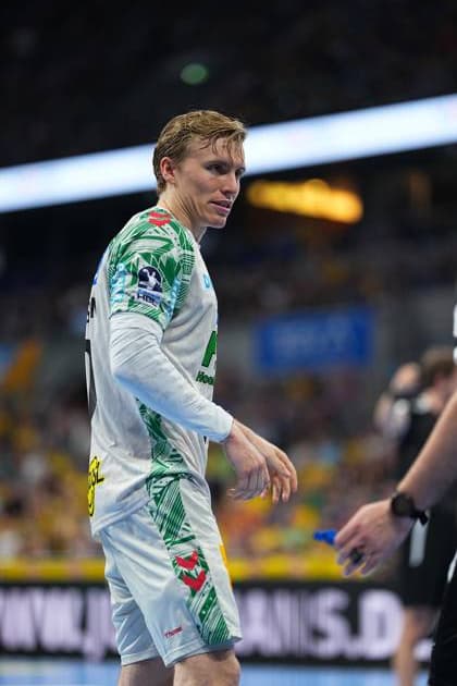 Gisli Thorgeir Kristjansson 10 SC Magdeburg stands in the white Magdeburg jersey on the pitch of the SAP Arena and looks to the side The yellow-clad fans of the Rhein Neckar Löwen can be seen in the background Gisli Thorgeir Kristjansson 10 SC Magdeburg in the SAP Arena Copyright: xspeedshotx