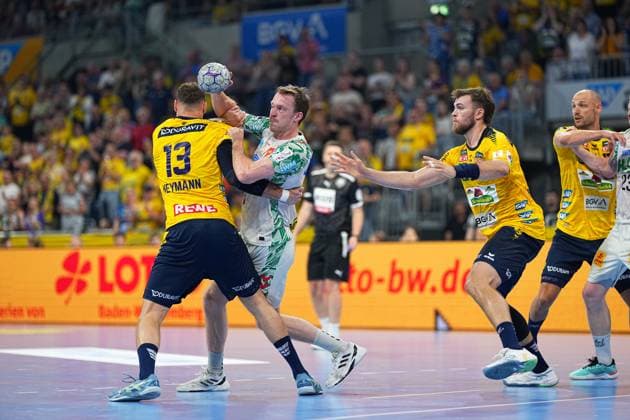Sebastian Heymann 13 Rhein Neckar Löwen confronts a white-clad SC Magdeburg player in attack, who lifts the ball over his head In the background, Lukas Sandell and Steven Plucnar Jacobsen can be seen both Rhein Neckar Löwen in the defensive formation Sebastian Heymann 13 Rhein Neckar Löwen blocks SC Magdeburg attacker Copyright: xspeedshotx
