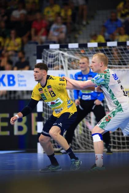 Sebastian Heymann 13, Rhein Neckar Löwen tackles Magnus Saugstrup 23, SC Magdeburg, who tries to stop him In the background is goalkeeper David Späth 29, Rhein Neckar Löwen in goal Sebastian Heymann 13 Rhein Neckar Löwen tackling Magnus Saugstrup 23 SC Magdeburg Copyright: xspeedshotx