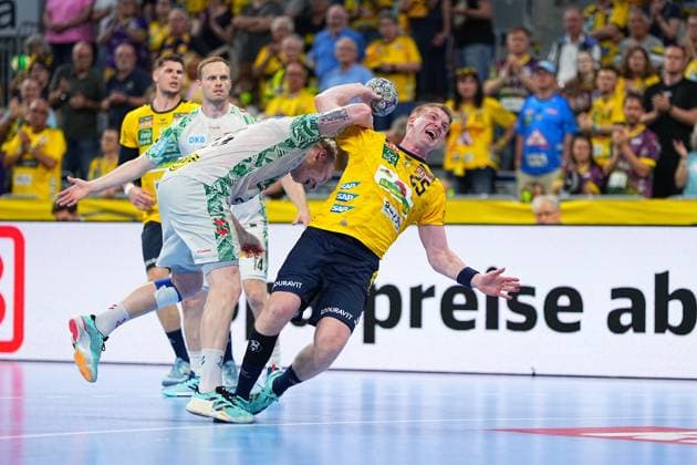 Haukur Thrastarson 25, Rhein Neckar Löwen in yellow jersey pulls up for a throw and is blocked by Omar Ingi Magnusson 14, SC Magdeburg in white jersey Sebastian Heymann 13, Rhein Neckar Löwen can be seen in the background, while the packed SAP Arena frames the scene Haukur Thrastarson 25 Rhein Neckar Löwen throwing against Omar Ingi Magnusson Copyright: xspeedshotx