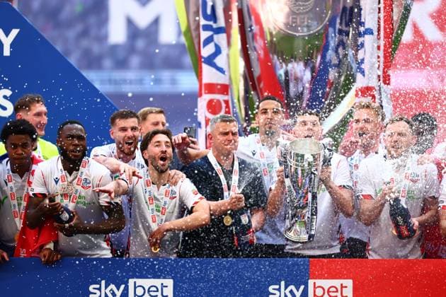 Bolton Wanderers manager Steven Schumacher of Bolton Wanderers with Eoin Toal , Josh Sheehan and the rest of the team celebrate with the League One Play off final trophy Bolton Wanderers v Stockport County, EFL Sky Bet League One, Play-Off Final, Football, Wembley Stadium, London, UK - 24 May 2026London Wembley Stadium United Kingdom EDITORIAL USE ONLY No use with unauthorised audio, video, data, fixture lists, club league logos or live services. Online in-match use limited to 120 images, no video emulation. No use in betting, games or single club league player publications.  Copyright: xJoexToth Shutterstockx 16889806gy