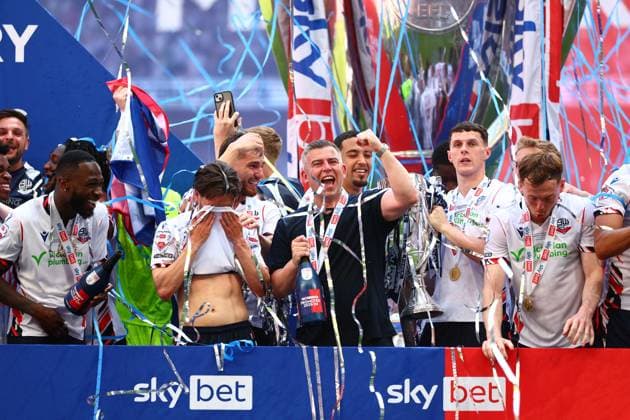 Bolton Wanderers manager Steven Schumacher of Bolton Wanderers with Eoin Toal , Josh Sheehan and the rest of the team celebrate with the League One Play off final trophy Bolton Wanderers v Stockport County, EFL Sky Bet League One, Play-Off Final, Football, Wembley Stadium, London, UK - 24 May 2026London Wembley Stadium United Kingdom EDITORIAL USE ONLY No use with unauthorised audio, video, data, fixture lists, club league logos or live services. Online in-match use limited to 120 images, no video emulation. No use in betting, games or single club league player publications.  Copyright: xJamesxMarsh Shutterstockx 16889809db