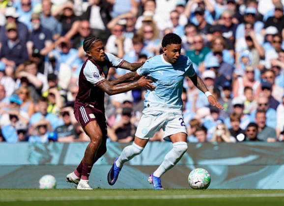 Manchester, England, 24th May 2026. Leon Bailey of Aston Villa grabs Savinho of Manchester City during the Manchester City vs Aston Villa Premier League match at the Etihad Stadium, Manchester. Picture credit should read: Andrew Yates Sportimage EDITORIAL USE ONLY. No use with unauthorised audio, video, data, fixture lists, club league logos or live services. Online in-match use limited to 120 images, no video emulation. No use in betting, games or single club league player publications. SPI_018_AY_Man_City_Villa SPI-4819-0024