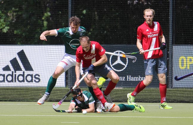 Mens field field hockey Bundesliga Alster player Jack Heldens fighting for the ball with Lukas Mertgens and Max Godau on the ground
