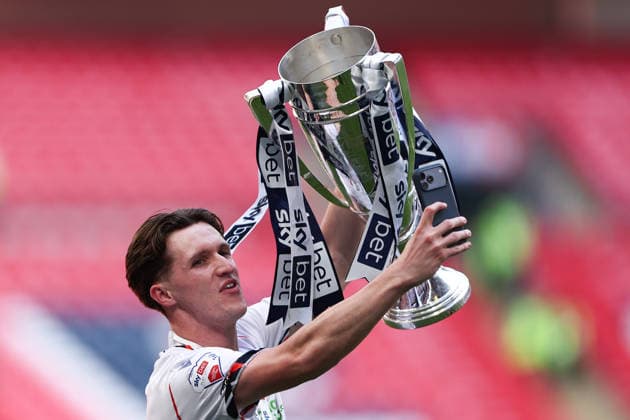 London, England, 24th May 2026. Johnny Kenny of Bolton Wanderers holds up the trophy following victory during the Bolton Wanderers vs Stockport County Sky Bet League 1 play off final match at Wembley Stadium, London. Picture credit should read: Jake Youle Sportimage EDITORIAL USE ONLY. No use with unauthorised audio, video, data, fixture lists, club league logos or live services. Online in-match use limited to 120 images, no video emulation. No use in betting, games or single club league player publications. SPI_091_JY_Stockport_County_Bolton_Wanderers SPI-4821-0091