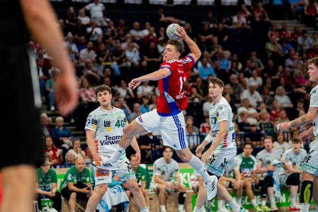 Oskar Sunnefeldt from Frisch Auf Göppingen jumps off in the Barclays Arena and throws the ball over the defense of HSV Hamburg Elias Newel 40 and other Göppingen players watch the action during the DAIKIN Handball Bundesliga match Handball Sport Verein Hamburg vs Frisch Auf Göppingen Copyright: xPhilippHeistx