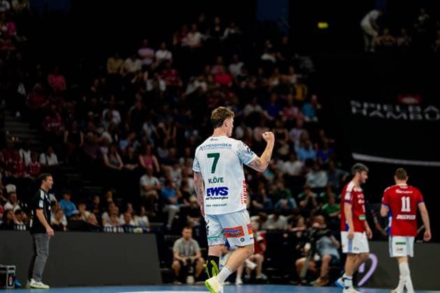 Victor Klöve wears the white jersey of Frisch Auf Göppingen with the number 7 and cheers after a successful goal throw in the Barclays Arena In the background you can see players of HSV Hamburg in red jerseys and spectators of the arena Handball Sport Verein Hamburg vs Frisch Auf Göppingen Copyright: xPhilippHeistx