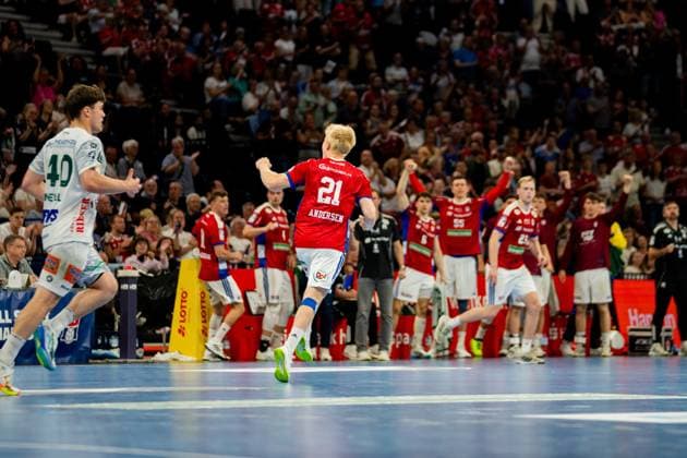 Frederik Bo Andersen 21 HSV Hamburg runs across the pitch at Barclays Arena with his fist clenched in jubilation as his team in red jerseys cheer behind him A player from Frisch Auf Göppingen 40 in white jersey is visible on the left Handball Sport Verein Hamburg vs Frisch Auf Göppingen Copyright: xPhilippHeistx