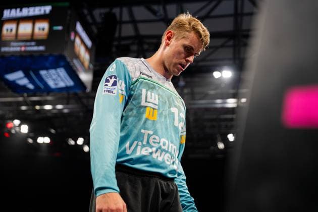 A Frisch Auf Göppingen player in a turquoise jersey stands thoughtfully on the pitch of the Barclays Arena The scoreboards and arena infrastructure are visible in the background Handball Sport Verein Hamburg vs Frisch Auf Göppingen Copyright: xPhilippHeistx