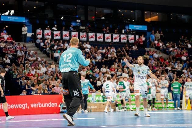 Kristian Saeveras wears the light blue jersey of Frisch Auf Göppingen and moves around the pitch of the Barclays Arena Several players from both teams are positioned in the match scene while spectators watch the game Handball Sport Verein Hamburg vs Frisch Auf Göppingen Copyright: xPhilippHeistx