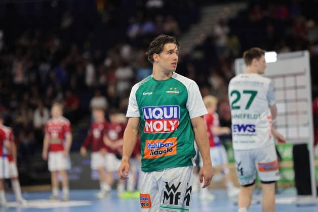 Player in green jersey with white sleeves from Frisch Auf Göppingen stands on the pitch of the Barclays Arena during a stoppage in play Other players and spectators in the hall are visible in the background Oskar Sunnefeldt 27 Frisch Auf Göppingen during a stoppage in play Copyright: xspeedshotx