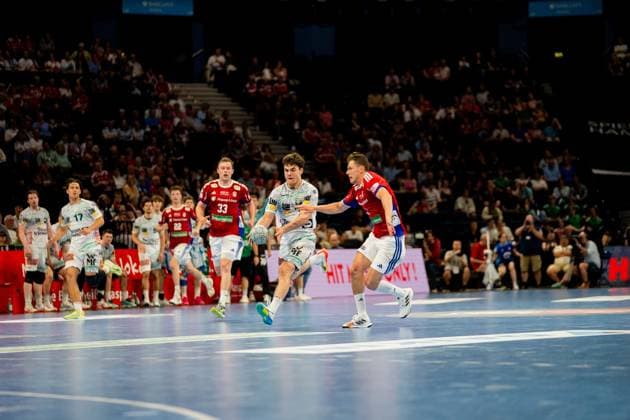 Elias Newel from Frisch Auf Göppingen white jersey with ball in attack against Moritz Sauter from HSV Hamburg red jersey in the Barclays Arena Intense defensive situation during the DAIKIN Handball Bundesliga match with numerous spectators in the background Handball Sport Verein Hamburg vs Frisch Auf Göppingen Copyright: xPhilippHeistx