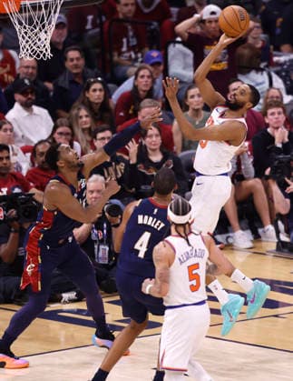 New York Knicks Mikal Bridges (25) shoots over Cleveland Cavaliers Donovan Mitchell (45) and Evan Mobley (4) in the second quarter of the Eastern Conference Final game 4 in Cleveland, Ohio Monday May 25, 2026.  CLE20260525110 AARONxJOSEFCZYK