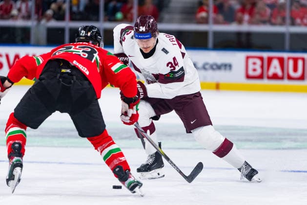 ZURICH, SWITZERLAND - MAY 26: Zeteny Hadobas (Hungary, 23) in the battle for the puck with Eduards Tralmarks (Latvia,34) during the Preliminary Round - Group A Match 51 between Hungary and Latvia at the IIHF Ice hockey, Eishockey World Championship, WM, Weltmeisterschaft 2026, Swiss Life Arena on May 26, 2026 in Zurich, Switzerland. Zurich Switzerland Copyright: xTimoxSteinx