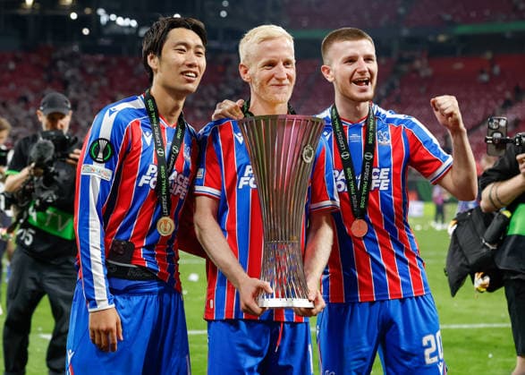 Leipzig, Germany, 27th May 2026. Daichi Kamada (left), Will Hughes (centre) and Adam Wharton (right) of Crystal Palace pose with the UEFA Conference League trophy following the Crystal Palace vs Rayo Vallecano UEFA Conference League Final match at Leipzig Stadium, Leipzig. Picture credit should read: Cody Froggatt Sportimage EDITORIAL USE ONLY. No use with unauthorised audio, video, data, fixture lists, club league logos or live services. Online in-match use limited to 120 images, no video emulation. No use in betting, games or single club league player publications. SPI_121_CF_CRYSTAL_PALACE_V_RAYO_VALLECANO SPI-4827-0121