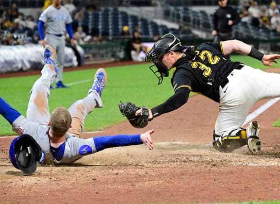 Chicago Cubs center fielder Pete Crow-Armstrong (4) rolls away from Pittsburgh Pirates catcher Henry Davis (32) after sliding into home, the Chicago Cubs wins the challenge overturning the original out call in the ninth inning of the Cubs 7-2 win at PNC Park on Thursday, May 28, 2026 in Pittsburgh.  PIT2026052829 ArchiexCarpenter