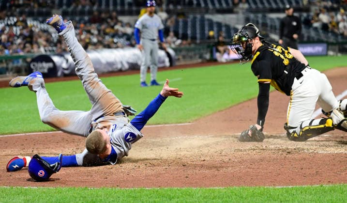 Chicago Cubs center fielder Pete Crow-Armstrong (4) rolls away from Pittsburgh Pirates catcher Henry Davis (32) after sliding into home, the Chicago Cubs wins the challenge overturning the original out call in the ninth inning of the Cubs 7-2 win at PNC Park on Thursday, May 28, 2026 in Pittsburgh.  PIT2026052830 ArchiexCarpenter