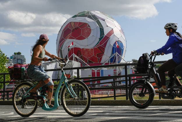 (260530) -- VANCOUVER, May 30, 2026 -- People ride past the dome of Science World as it is being transformed into a giant official match ball of the FIFA World Cup, WM, Weltmeisterschaft, Fussball 2026 ahead of the tournament in Vancouver, British Columbia, Canada, on May 29, 2026. (Photo by Xinhua) (SP)CANADA-VANCOUVER-FIFA WORLD CUP 2026 LiangxSen 