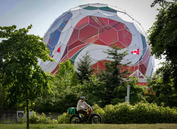 (260530) -- VANCOUVER, May 30, 2026 -- A person rides past the dome of Science World as it is being transformed into a giant official match ball of the FIFA World Cup, WM, Weltmeisterschaft, Fussball 2026 ahead of the tournament in Vancouver, British Columbia, Canada, on May 29, 2026. (Photo by Xinhua) (SP)CANADA-VANCOUVER-FIFA WORLD CUP 2026 LiangxSen 