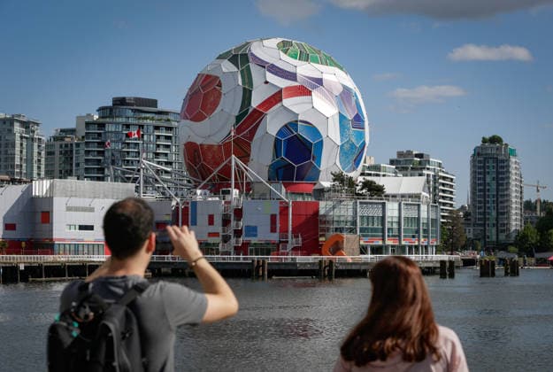 (260530) -- VANCOUVER, May 30, 2026 -- A man takes photos of the dome of Science World as it is being transformed into a giant official match ball of the FIFA World Cup, WM, Weltmeisterschaft, Fussball 2026 ahead of the tournament in Vancouver, British Columbia, Canada, on May 29, 2026. (Photo by Xinhua) (SP)CANADA-VANCOUVER-FIFA WORLD CUP 2026 LiangxSen 
