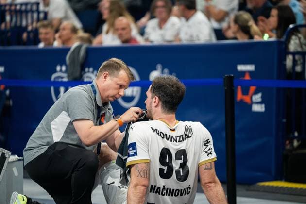 Veron Nacinovic 93 THW Kiel kneels on the sidelines and is treated on the neck and chin by a coach Spectators of the EHF European League Finals can be seen in the background EHF European League THW Kiel Montpellier HB, 30 05 2026, Hamburg, Barclays Arena Copyright: xPhilippHeistx
