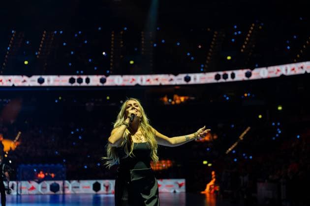 A singer with long blonde hair performs with a microphone in her hand on the pitch of a handball arena The illuminated stands and perimeter advertising can be seen in the background EHF European League THW Kiel Montpellier HB, 30 05 2026, Hamburg, Barclays Arena Copyright: xPhilippHeistx