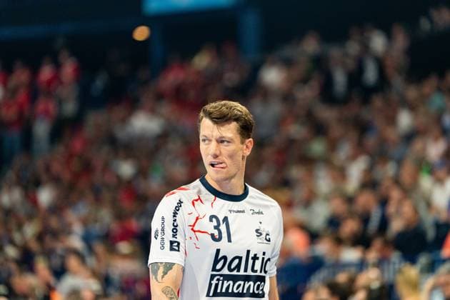 Emil Jakobsen 31 SG Flensburg Handewitt looks to the side in concentration, spectators in the packed arena can be seen in the background The left winger shows an intense facial expression during the match MT Melsungen vs SG Flensburg Handewitt - EHF Finals Hamburg 2026 Copyright: xPhilippHeistx
