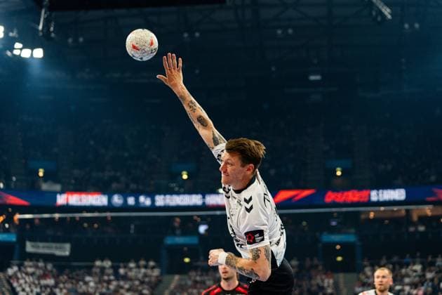 Emil Jakobsen 31 SG Flensburg Handewitt jumps high and throws the ball towards the goal In the background you can see other players and the scoreboard with the match MT Melsungen vs SG Flensburg Handewitt MT Melsungen vs SG Flensburg Handewitt - EHF Finals Hamburg 2026 Copyright: xPhilippHeistx