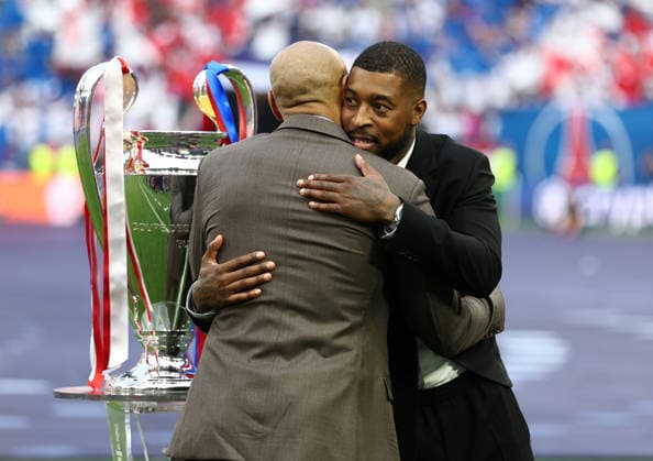 Budapest, Hungary, 30th May 2026. Former players Thierry Henry and Presnel Kimpembe hug after carrying out the Trophy during the Paris Saint Germain vs Arsenal UEFA Champions League Final match at Puskas Arena, Budapest. Picture credit should read: David Klein Sportimage EDITORIAL USE ONLY. No use with unauthorised audio, video, data, fixture lists, club league logos or live services. Online in-match use limited to 120 images, no video emulation. No use in betting, games or single club league player publications. SPI_065_DK_PSG_Arsenal SPI-4828-0064