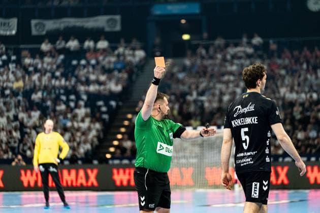 An EHF referee shows Niclas Kirkelokke 5 SG Flensburg Handewitt the red card In the background you can see the goalkeeper of Montpellier HB in the yellow jersey Red card for Niclas Kirkelokke 5 SG Flensburg Handewitt Copyright: xPhilippHeistx