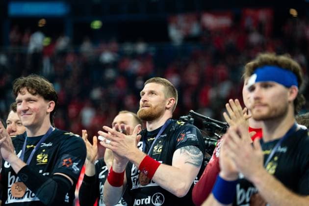 SG Flensburg Handewitt players, including Blaz Blagotinsek 43 and Lasse Møller 64 , applaud with medals around their necks Spectators in the arena can be seen in the background Blaz Blagotinsek 43 SG Flensburg Handewitt and Lasse Møller 64 SG Flensburg Handewitt at the award ceremony Copyright: xPhilippHeistx