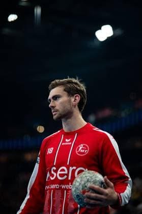 Florian Drosten 18 MT Melsungen stands in the hall with the ball in his hand and looks to the side with concentration The player wears the red jersey of MT Melsungen with the number 18 EHF European League Final 2026 THW Kiel vs MT Melsungen, 31 05 2026, Hamburg, Barclays Arena Copyright: xPhilippHeistx