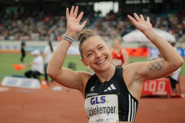 Gina Lückenkemper laughs as she raises both arms in the air after her race and celebrates with the crowd Her name and sponsor GLS can be read on her race license plate and she has an Olympic rings tattoo on her upper arm Gina Lückenkemper cheers at the Golden Oval Dresden Copyright: xspeedshotx xBeatricexBauerx