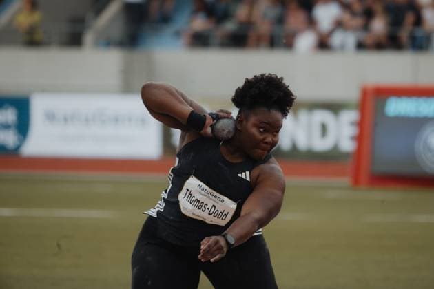 Danniel Thomas Dodd holds the ball by the cheek in the launch position and prepares the shot In the background, spectators in the stands can be seen Danniel Thomas Dodd JAM at the shot put approach Copyright: xspeedshotx xBeatricexBauerx