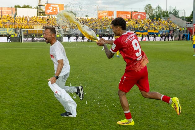 Jermain Nischalke FC Würzburger Kickers pours the beer glass triumphantly over the head of coach Michael Schiele to shower him traditionally after the successful promotion to the 3rd league The coach accepts the humorous action with great joy, AKON Arena am Dallenberg, Würzburg, Germany, on June 1, 2026 DFB DFL REGULATIONS PROHIBIT ANY USE OF PHOTOGRAPHS AS IMAGE SEQUENCES AND OR QUASI VIDEO, Copyright: HMBxMedia xHeikoxBecker