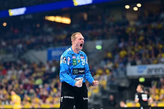 Goalkeeper David Späth 29 Rhein Neckar Löwen raises his fists and cheers with his mouth wide open Spectators dressed in yellow and a referee can be seen in the background David Späth 29 Rhein Neckar Löwen cheers loudly Copyright: xMichaelxGelhardtx