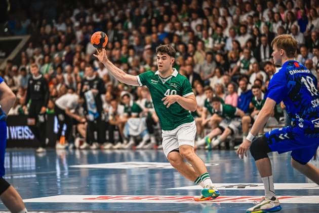 A player from Frisch Auf Göppingen 40 takes a shot with the ball in his hands A player from TVB Stuttgart 18 stands next to him in defense Player 40 Frisch Auf Göppingen attempting a shot against TVB Stuttgart Copyright: xspeedshotx xDorianfrickx