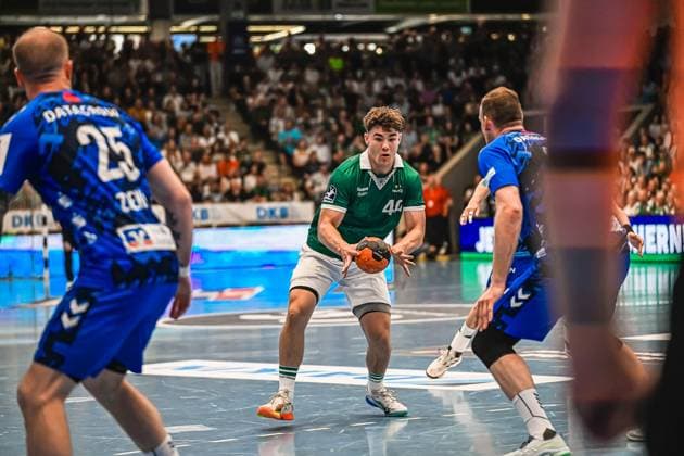 A Frisch Auf Göppingen player with the number 44 holds the ball and looks for an opportunity to attack Two TVB Stuttgart players surround him in defense Player 44 Frisch Auf Göppingen in attack against TVB Stuttgart Copyright: xspeedshotx xDorianfrickx