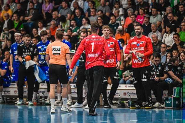 TVB Stuttgart goalkeeper Kornecki 1 stands with a teammate on the pitch near the touchline A referee in an orange jersey can also be seen in the picture Kornecki 1 TVB Stuttgart talking on the touchline Copyright: xspeedshotx xDorianfrickx