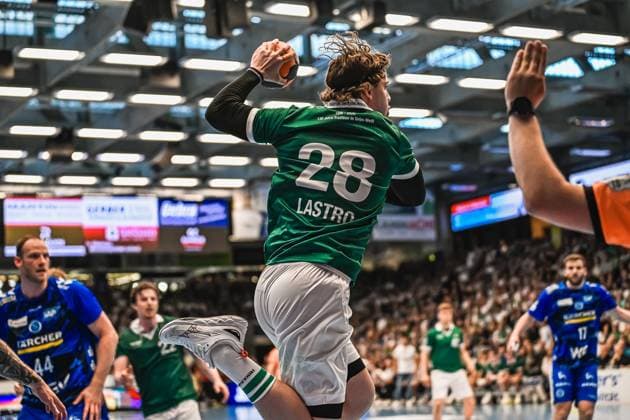 Franko Lastro 28 Frisch Auf Göppingen jumps off and pulls up for the throw, while Lenny Rubin 44 TVB Stuttgart can be seen on the left of the picture as a defender The outstretched arm of a referee can be seen on the right of the picture Franko Lastro 28 Frisch Auf Göppingen throwing against TVB Stuttgart Copyright: xspeedshotx xDorianfrickx
