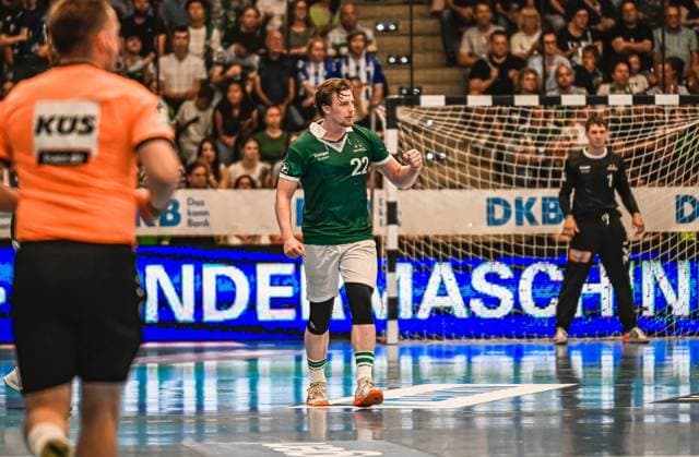 Erik Persson 22 Frisch Auf Göppingen runs across the pitch celebrating with a clenched fist A goalkeeper in a black jersey and a referee in orange can be seen in the background Erik Persson 22 Frisch Auf Göppingen celebrates scoring a goal Copyright: xspeedshotx xDorianfrickx