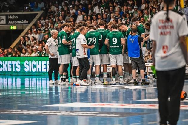 The Frisch Auf Göppingen team gathers on the pitch during a time-out for a tactical discussion Visible are Franko Lastro 28 Frisch Auf Göppingen and Niklas Herberger 9 Frisch Auf Göppingen Frisch Auf Göppingen Time-out discussion with coach Ben Matschke Copyright: xspeedshotx xDorianfrickx
