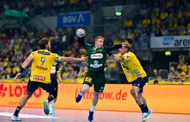 Jonathan Edvardsson 26 TSV Hannover Burgdorf jumps to shoot and is blocked in the air by two Rhein Neckar Löwen players, including Steven Plucnar Jacobsen 9 Rhein Neckar Löwen The scene takes place in front of a sold-out crowd in the SAP Arena Jonathan Edvardsson 26 TSV Hannover Burgdorf in a jump shot against Rhein Neckar Löwen Copyright: xMichaelxGelhardtx