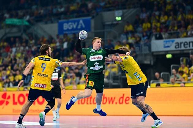 Bendix Dietzsch 20 TSV Hannover Burgdorf jumps up with the ball and takes a shot, while Steven Plucnar Jacobsen 9 Rhein Neckar Löwen on the left and another Löwen player on the right try to block the shot The scene takes place in the SAP Arena in front of a full crowd Bendix Dietzsch 20 TSV Hannover Burgdorf in a jump shot between two Löwen defenders Copyright: xMichaelxGelhardtx