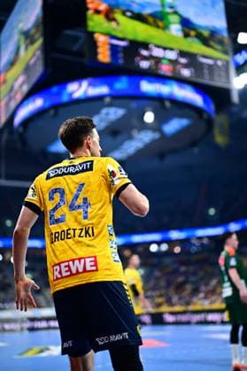 Patrick Groetzki 24 Rhein Neckar Löwen stands on the pitch with his back to the camera and watches the action In the background you can see players from TSV Hannover Burgdorf and the arena scoreboard Patrick Groetzki 24 Rhein Neckar Löwen watching the action Copyright: xMichaelxGelhardtx