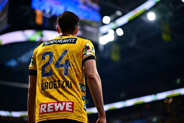 Patrick Groetzki 24 Rhein Neckar Löwen stands with his back to the camera, his jersey with number and name is clearly visible In the background, the illuminated arena is blurred Patrick Groetzki 24 Rhein Neckar Löwen from behind in the arena Copyright: xMichaelxGelhardtx